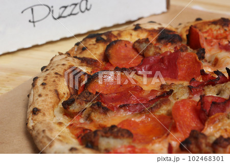 Fresh Pizza on Wooden Table at Restaurant Sliced and Ready to Eat Fresh Pizza on Wooden Table at Restaurant Sliced and Ready to Eat 102468301