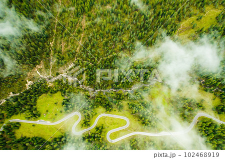 Nestled within magnificent forests and vibrant autumn meadows lies the world-renowned Snake Road, covered by clouds, top view.  102468919