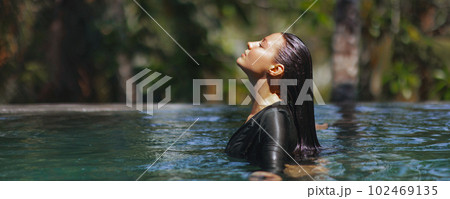 Beach woman relaxation in luxury infinity pool at tropical resort spa on vacation Beach woman relaxation in luxury infinity pool at tropical resort spa on vacation 102469135