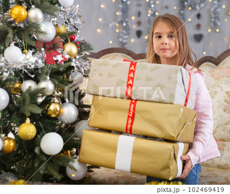 Happy girl with a box of gifts on the background of the Christmas tree on holiday of Christmas 102469419