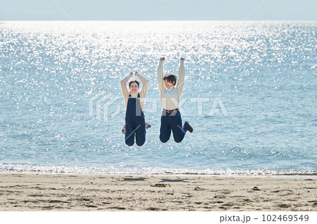 海でジャンプする若い女性と友達 海でジャンプする若い女性と友達 102469549