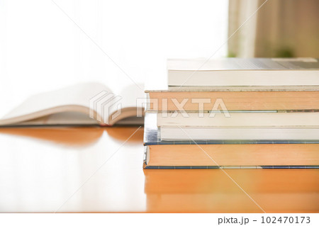 机の上に開いた英語の書籍 研究 学習 学び直しのイメージ 102470173