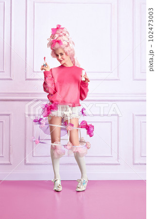 Portrait with young girl, princess, queen wearing pink clothes and playing with bubbles over luxury interior background. Renaissance fashion 102473003