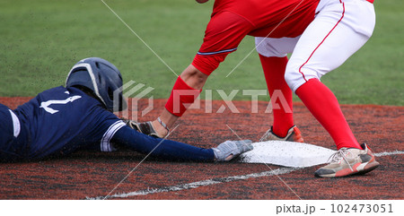 Third baseman tagging out runner who is head first sliding 102473051