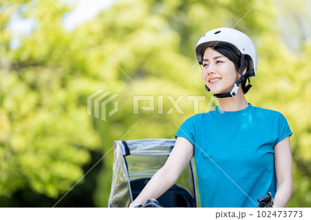 ヘルメットをかぶって自転車を扱う女性。 102473773