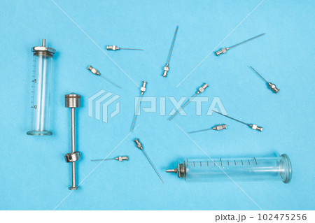 view of hypodermic needles and syringes on blue 102475256