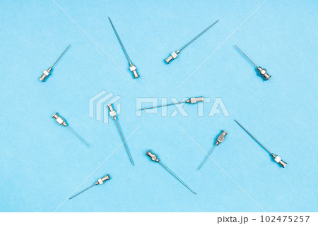 top view of vintage hypodermic needles on blue 102475257