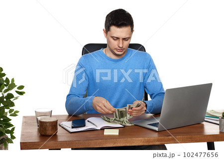 handsome businessman working on laptop and holding money 102477656