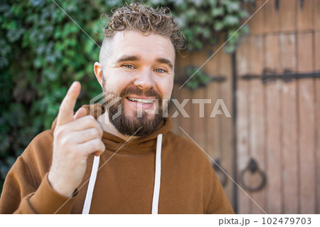 Handsome curly man takes a video of himself - video blog and youth blogger concept 102479703