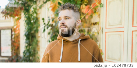 Banner Close up shot of curly European male with beard wears switshot outdoors copy space. Handsome man with crisp light hair. Banner Close up shot of curly European male with beard wears switshot outdoors copy space. Handsome man with crisp light hair. 102479735