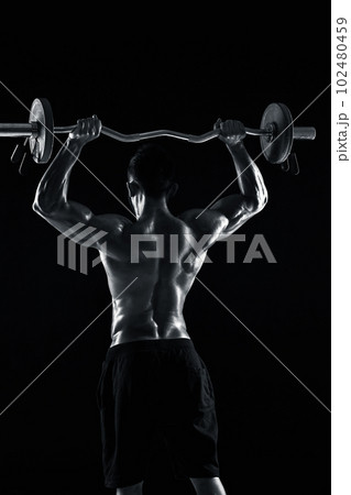 bodybuilder lifting a barbell on black background bodybuilder lifting a barbell on black background 102480459