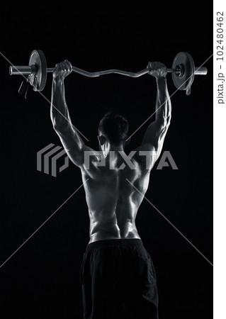 bodybuilder lifting a barbell on black background 102480462