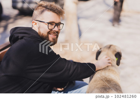 Man stroking a homeless dog - pet and street dog concept 102481260