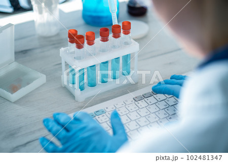 The clinician analyzes the data of patients undergoing cancer treatment on a computer in a chemical laboratory. Pharmaceutical scientist reviews results of experiment on new drugs The clinician analyzes the data of patients undergoing cancer treatment on a computer in a chemical laboratory. Pharmaceutical scientist reviews results of experiment on new drugs 102481347