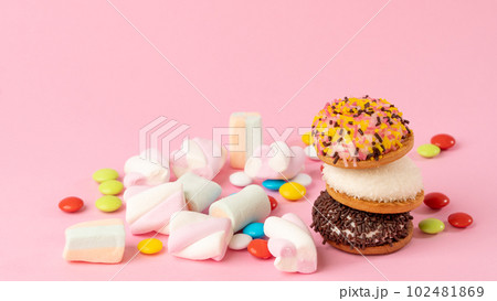 Sweets - cake, sweets, dragees, marshmallows on a pink background 102481869