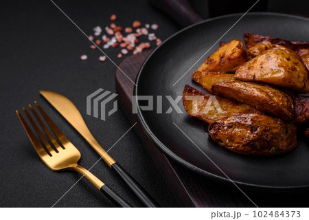 Delicious grilled potato slices with garlic, spices and herbs 102484373