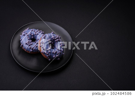 Delicious sweet donut of purple color in glaze and with lilac balls 102484586