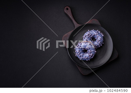 Delicious sweet donut of purple color in glaze and with lilac balls 102484590