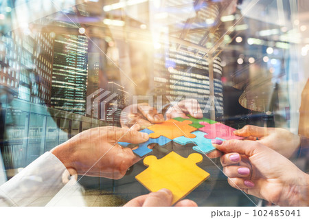 Teamwork of partners connect puzzle pieces as integration and startup 102485041