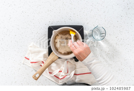 Flat lay. Caramelizing sugar in a saucepan to make caramel cupcake toppers. 102485987