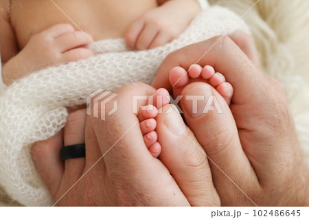 Mother is doing massage on her baby foot. Closeup baby feet in mother hands. Prevention of flat feet, development, muscle tone, dysplasia. Family, love, care, and health concepts. Studio macro. Mother is doing massage on her baby foot. Closeup baby feet in mother hands. Prevention of flat feet, development, muscle tone, dysplasia. Family, love, care, and health concepts. Studio macro. 102486645