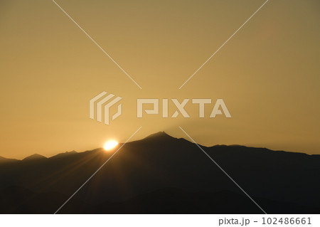 北杜市白州町、金峰山から昇る太陽が空を黄金色に染めて行く 102486661