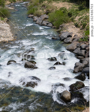 春の雪解け水で溢れる清流 102486703