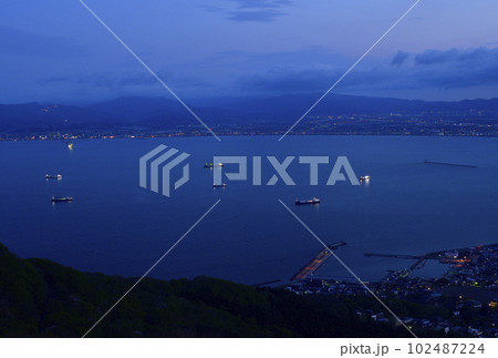 春の北海道函館市函館湾に停泊中する貨物船の日の出前の風景を函館山から撮影 102487224