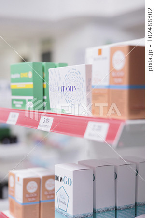 Selective focus of pharmacy shelves full with spf products and pharmaceuticals drugs boxes to sell prescription medicine or treatment to clients. Empty health care store filled with vitamins and pills 102488302