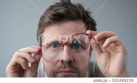 Surprised man in big glasses with WOW expression on gray backgound 102489259