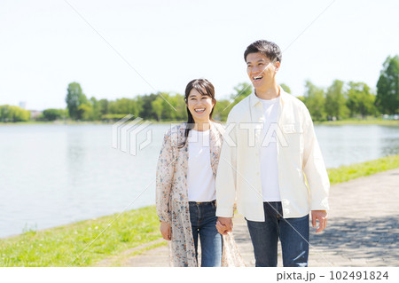 池の畔を歩く男女のポートレート 102491824