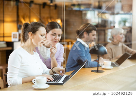 Female designers sitting in cafe with laptop and coffee Female designers sitting in cafe with laptop and coffee 102492129