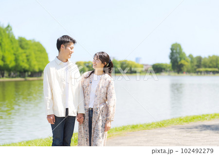 池の畔を歩く男女のポートレート 102492279