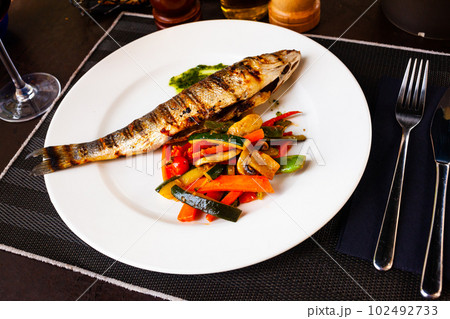 Sea bass, grilled with zucchini, pepper and mushrooms 102492733