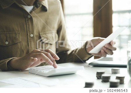 Accountant using calculator for calculate finance report in office. 102496543