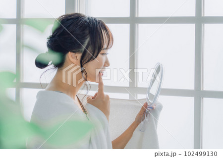 鏡で歯を見て困るアジア人女性(虫歯・歯並び・歯周病) 鏡で歯を見て困るアジア人女性(虫歯・歯並び・歯周病) 102499130