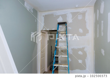 During process of being plastered with drywall newly constructed house is ready for painting after being plastered drywall During process of being plastered with drywall newly constructed house is ready for painting after being plastered drywall 102500373