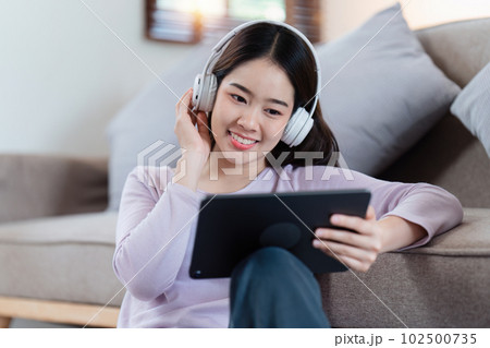 Attractive Asian woman resting comfortable living room and using digital tablet, Relax, Sofa, Lifestyle Attractive Asian woman resting comfortable living room and using digital tablet, Relax, Sofa, Lifestyle 102500735