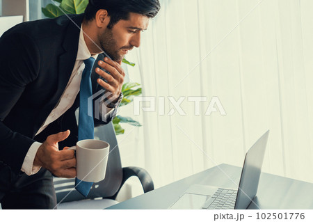 Professional businessman at modern office desk with confused expression. fervent 102501776