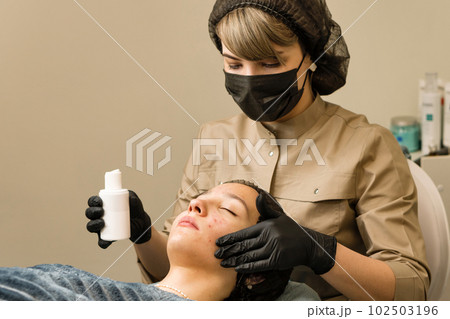 Beautician apply serum for face on teen skin 102503196