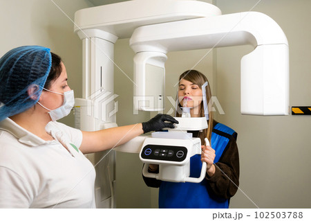 X-ray technician makes CT scan of jaw 102503788