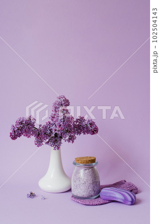 Lilac spa. Sea salt, washcloth mitten, lilac flowers, sea salt handmade soap. Natural herbal cosmetics with flowers on a light background. Relaxation concept. Cosmetic procedures. Copy space. 102504143