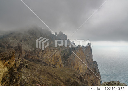 Dead city in fog and clouds. Khoba-Tele Ridge of Karadag Reserve in spring. Crimea 102504382