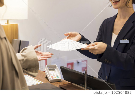 ホテルチェックイン手続きをする若い女性 102504883