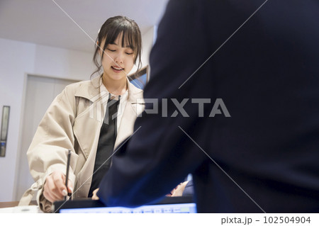 ホテルチェックイン手続きをする若い女性 ホテルチェックイン手続きをする若い女性 102504904