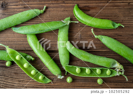 Fresh pea pods on a wooden background Fresh pea pods on a wooden background 102505292