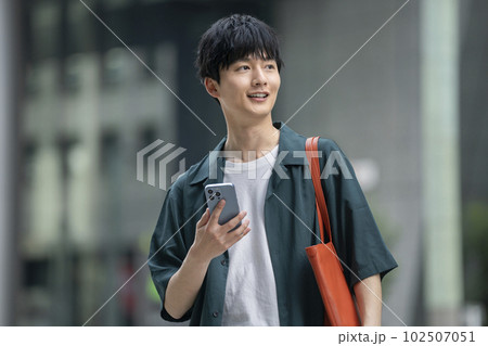 スマートフォンを持った若い男性 102507051