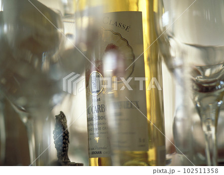 薄暮の光を受けてうっすらと光るワイングラスと白ワイン 薄暮の光を受けてうっすらと光るワイングラスと白ワイン 102511358