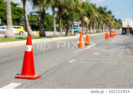 Road construction works. Traffic cones at street warning about asphalt pavement works . Road construction works. Traffic cones at street warning about asphalt pavement works . 102512954