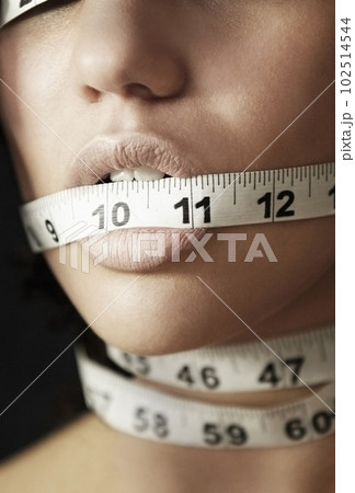 Anorexia, measuring tape and suffering with mouth of woman for eating disorder, weight loss and fear. Diet, frustrated and mental health with closeup of female for anxiety, stress and bulimia problem Anorexia, measuring tape and suffering with mouth of woman for eating disorder, weight loss and fear. Diet, frustrated and mental health with closeup of female for anxiety, stress and bulimia problem 102514544